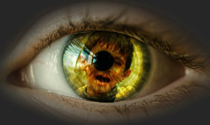 reflection of young boy suffering in an eye